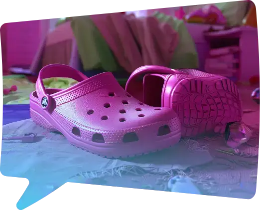 Un par de zuecos rosa fucsia sobre una cama